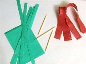 Brug rødt og grønt quillingpapir. Skær den i brede og smalle strimler. Lav snit på de røde striber.