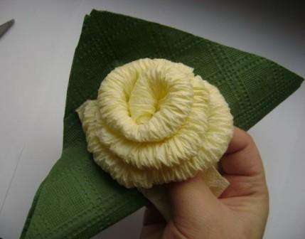 Tag derefter grønne servietter for at lave blomsterblade. Fold servietterne ind i en trekant og pak den ind i bunden af ​​opløbet. Du burde få et blad. Lav tre af disse blade til en rose.