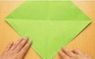 Βάζουμε το τετράγωνο χαρτιού με μια γωνία προς το μέρος μας και λυγίζουμε την κάτω γωνία στο κέντρο του τετραγώνου