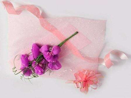 Pak buketten ind med plastfolie, bind den med et bredt lyserødt bånd og fastgør en sløjfe.