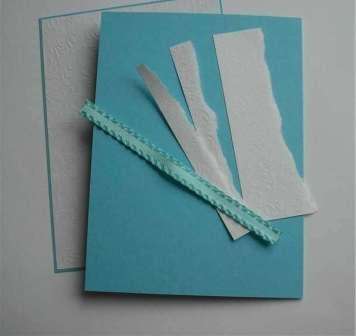 Zo silného tyrkysového papiera odstrihnite obdĺžnik 14 × 18 cm. Zložte tento papier rovnomerne na polovicu. Potom vystrihnite menší obdĺžnik z bieleho papiera - 13 × 17 cm. Pomocou obojstrannej pásky prilepte tieto dva listy papiera k sebe. Potom opatrne orežte okraje tyrkysového papiera tak, aby nevyčnievali viac ako 0,5 cm.