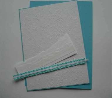 Για να κάνετε παρασύρσεις, αρκεί να κόψετε μερικές λωρίδες λευκού χαρτιού. Κολλήστε τα παρασυρόμενα στην προετοιμασμένη βάση καρτ ποστάλ. Πάρτε μια μπλε σατέν κορδέλα και ράψτε μια λευκή κορδέλα σε αυτήν. Κολλήστε αυτό το στοιχείο διακόσμησης με ένα πιστόλι κόλλας στο κάτω μέρος της καρτ ποστάλ.