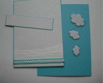 Leikkaa 13,5 x 2,5 cm suorakulmio turkoosista paperista ja 13 x 2,5 cm suorakulmio valkoisesta paperista. Sinun on sijoitettava tämä pala postikortin yläosaan. Leikkaa pilvet valkoisesta huopasta ja liimaa ne tähän suorakulmioon.