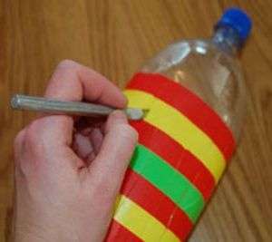 Med en papirkniv skal du skære flasken langs linjerne. Du behøver kun at skære den lige del, som er forseglet med elektrisk tape. Afstanden til bunden af ​​flasken skal være omkring 2-3 cm.