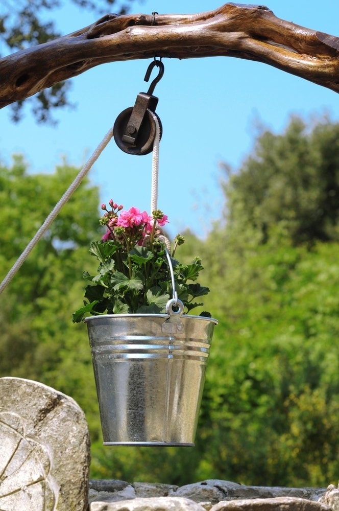 En slags dekorativ brønd i form af en blomsterpotte bliver en rigtig dekoration til din have